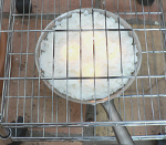 Stainless omelet pan filled with soy wax. 4 wicks are lit.